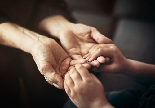 A child's hands holding an older adult's hands